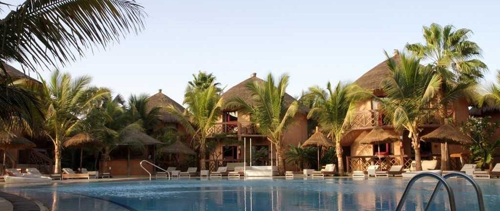 Piscine extérieure, palmiers et chaises longues, transats à l'hôtel Lamantin 5* à Saly, au Sénégal